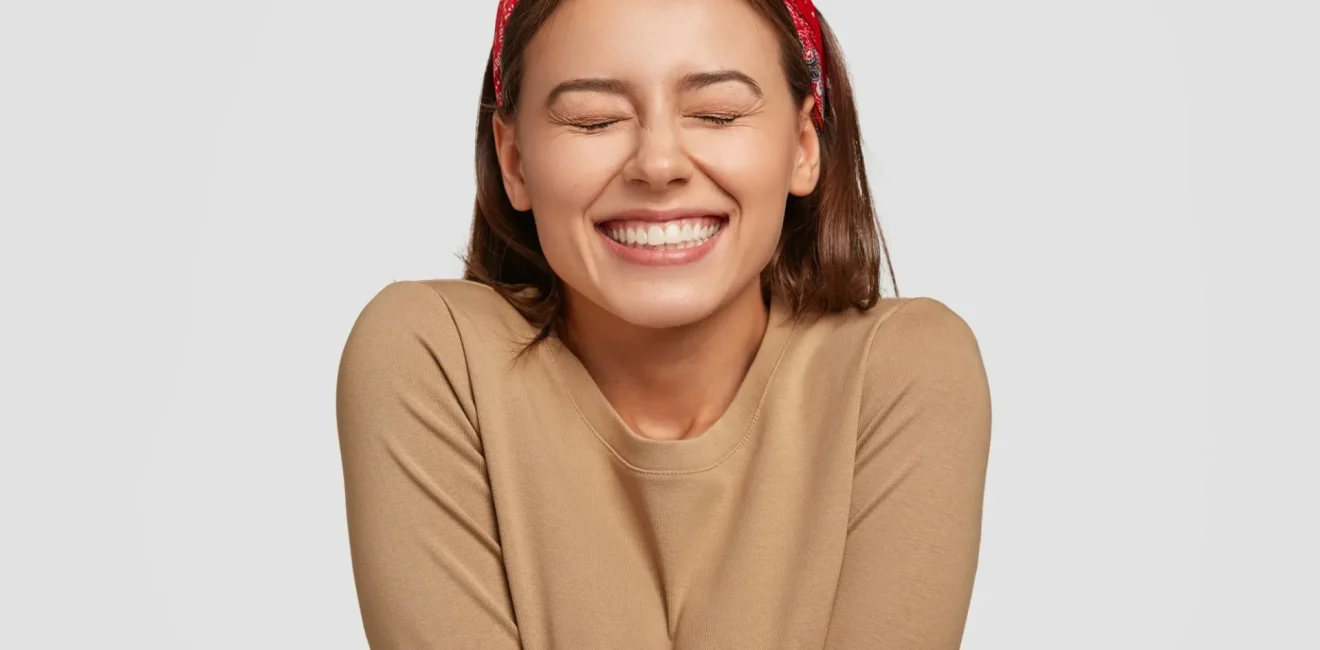 portrait-happy-european-woman-has-broad-smile-closes-eyes-feels-excitement-being-high-spirit